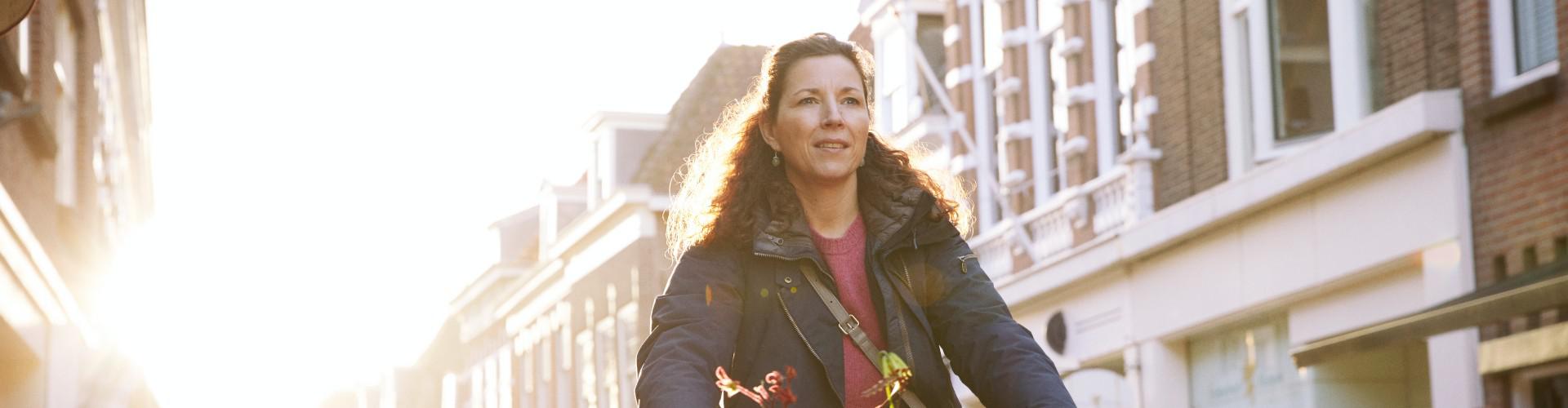 Vrouw op de fiets door de stad