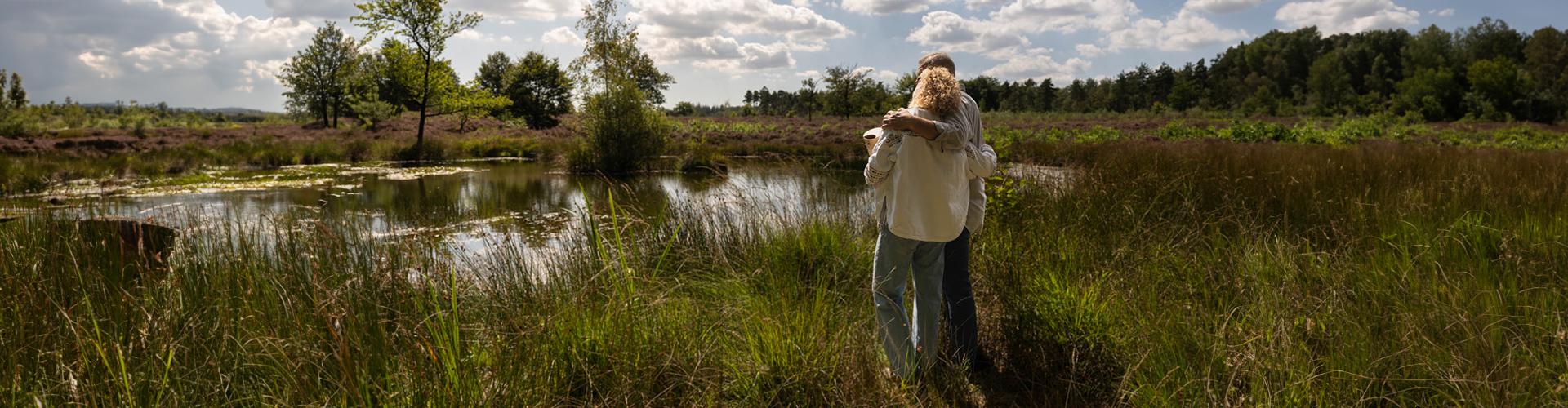 Man en vrouw kijken over meer